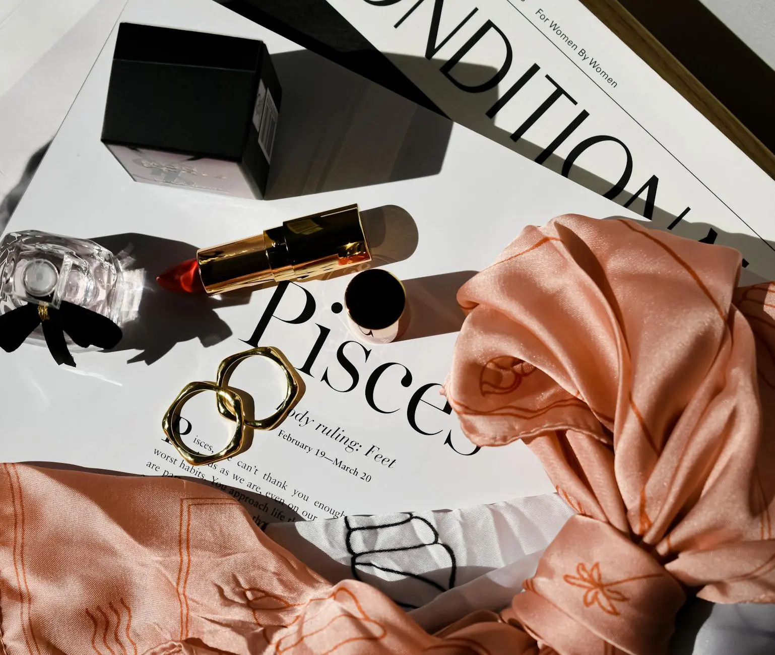 elegance lipstick and a bottle of perfume with two rings