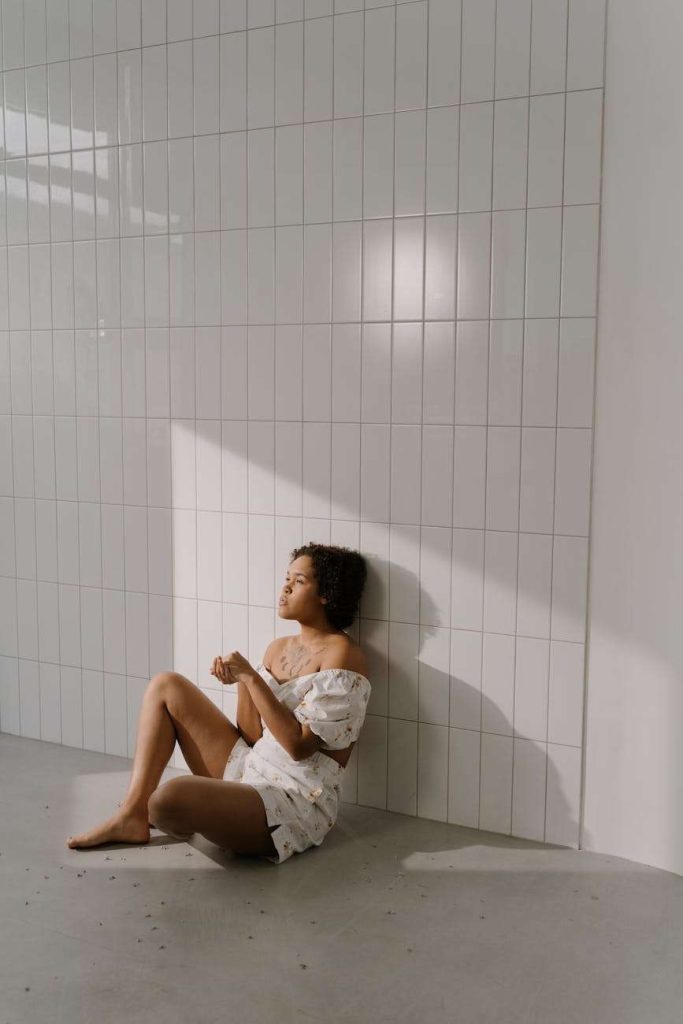 a tattooed woman sitting on the floor