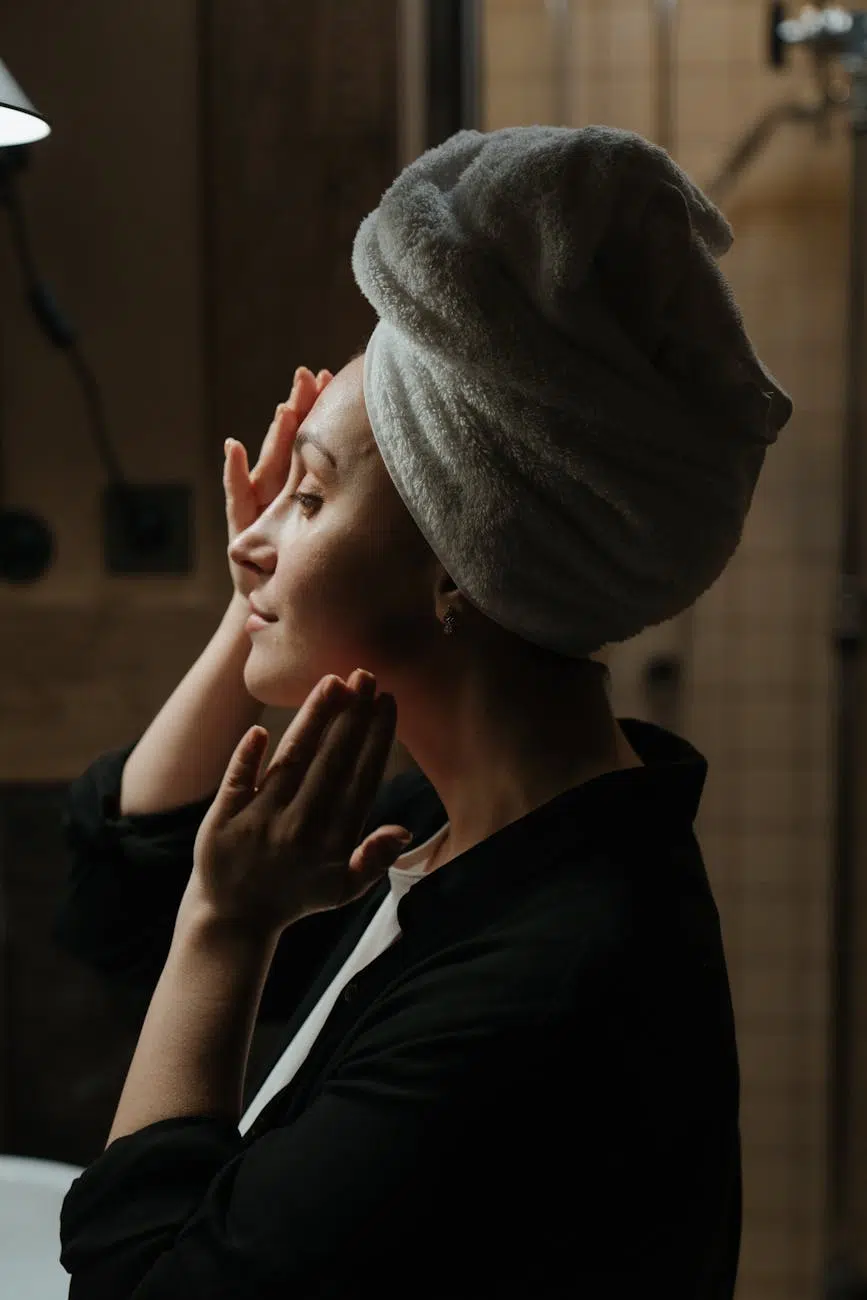 woman in black jacket covering her face with gray towel