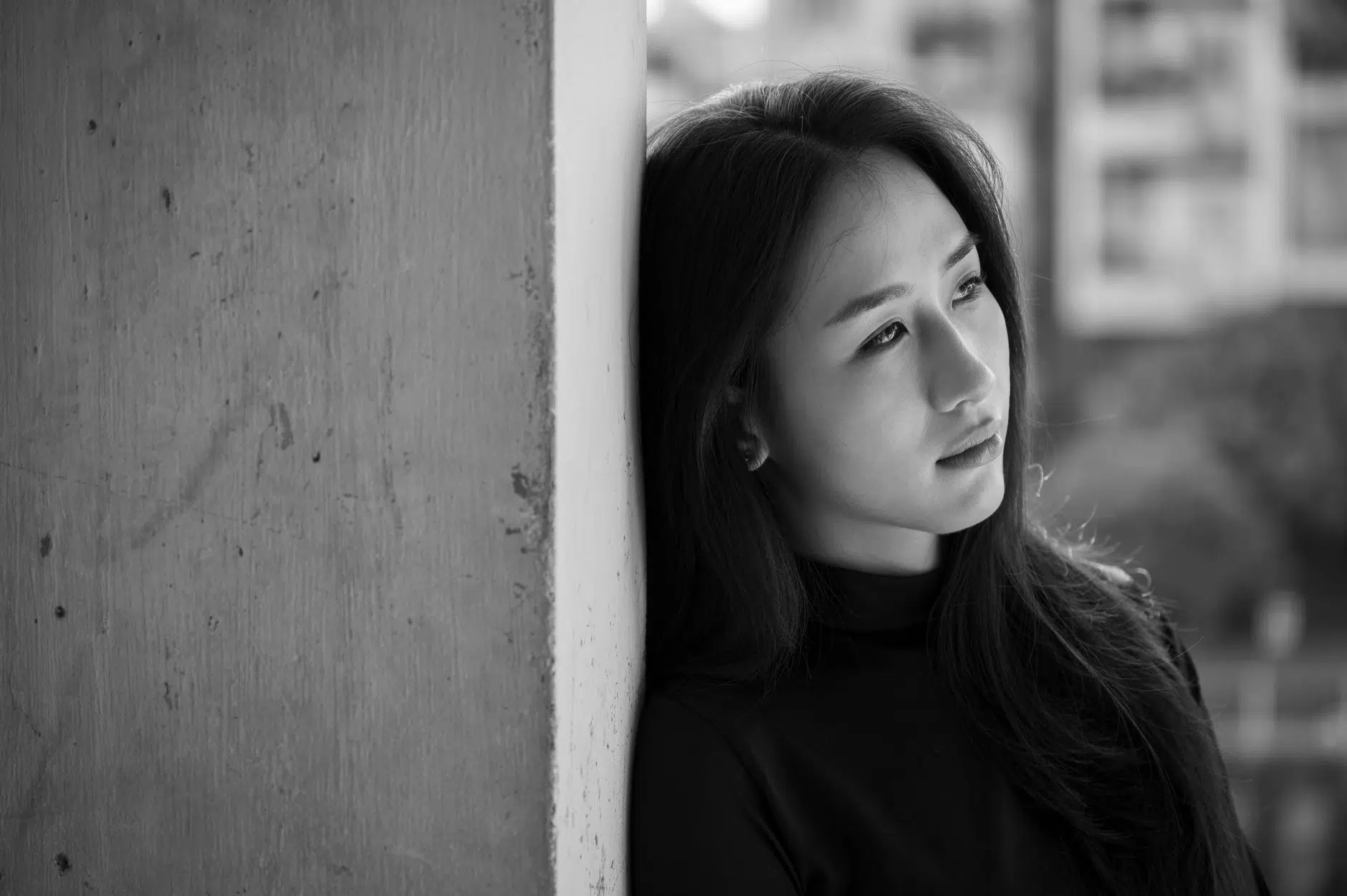 pexels-photo-34744495 choices thoughtful woman leaning against a wall in black and white